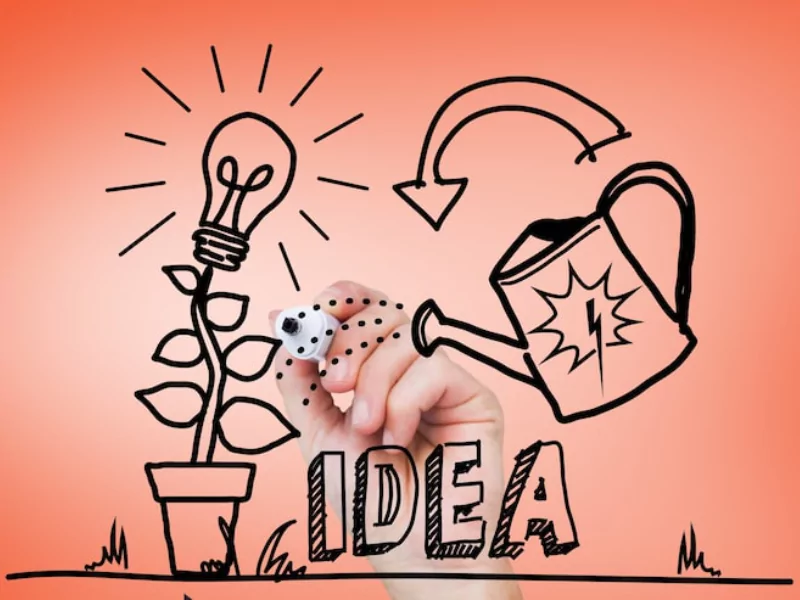 A hand watering a plant with lightbulbs, representing growth and creative passion project ideas